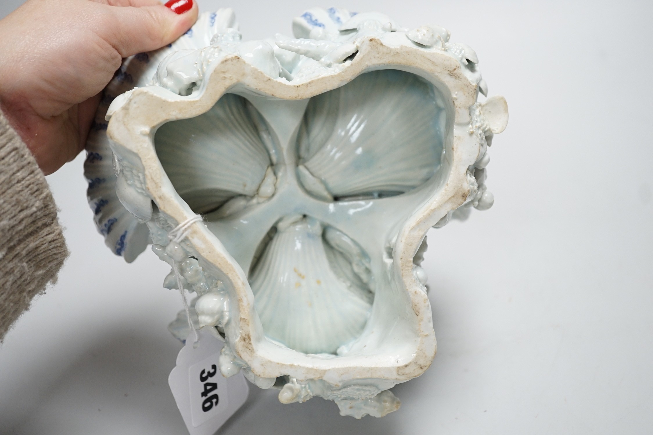 An early Bow porcelain three shell salt, the naturalistically modelled shells picked out in underglaze blue, on a shell and coral encrusted base, 8cm high